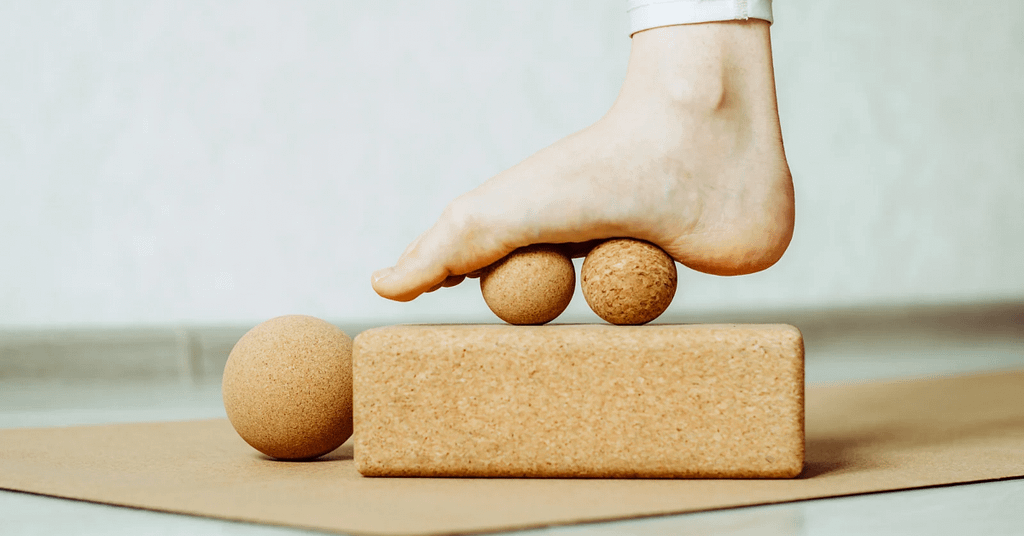 Foot rolling on massage balls to relieve plantar fasciitis pain and tension